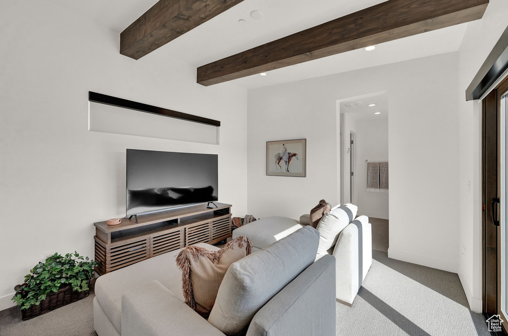 Carpeted living room featuring beamed ceiling