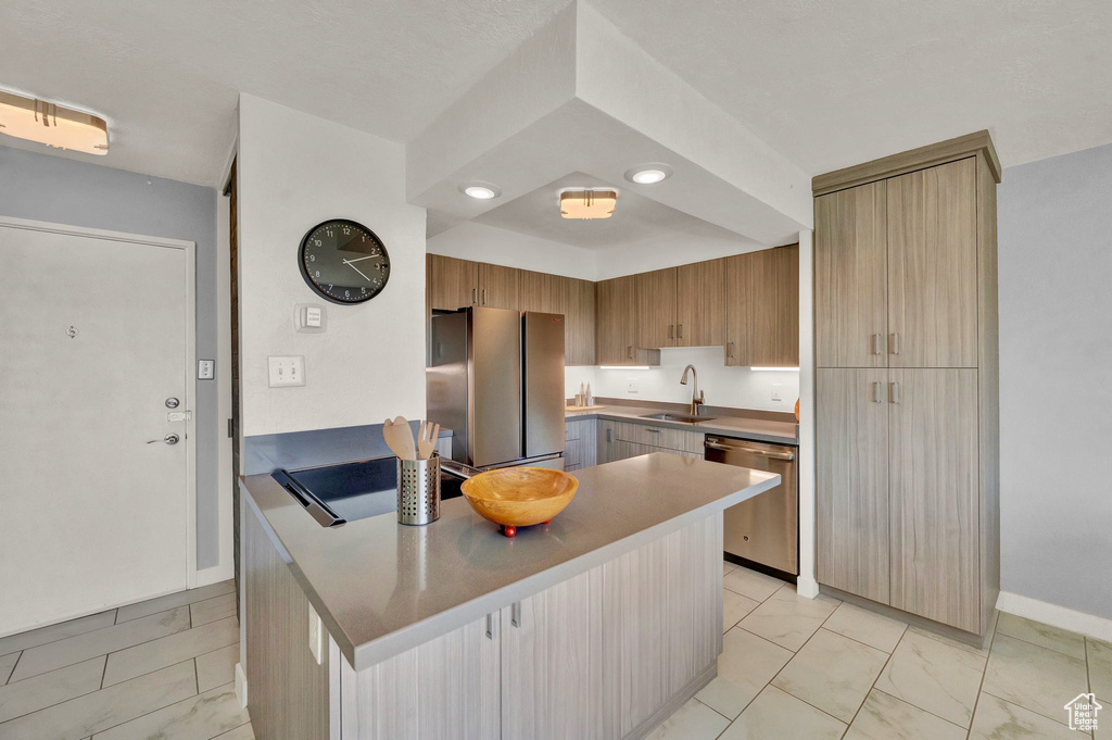 Kitchen with light tile patterned flooring, appliances with stainless steel finishes, and sink