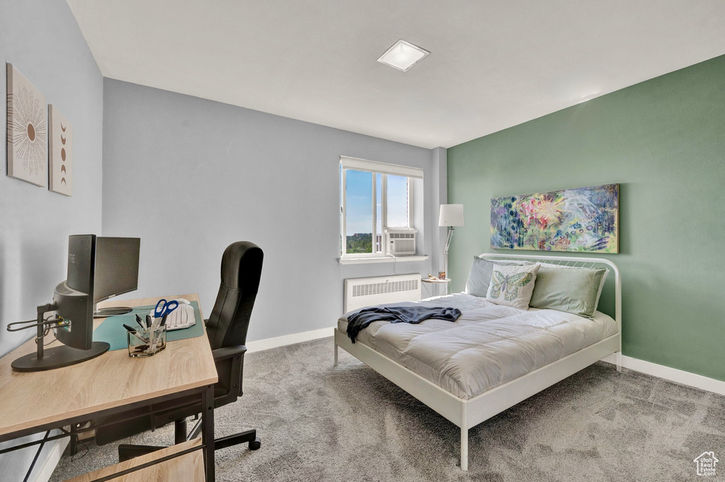 Bedroom with cooling unit, radiator, and carpet flooring