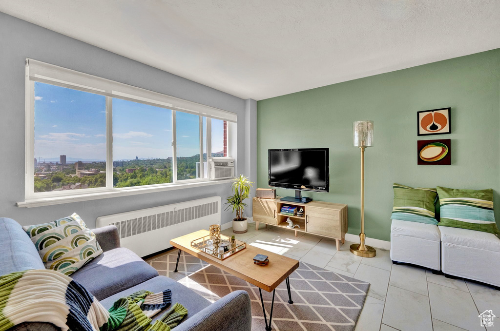 Living room featuring radiator, cooling unit, and light tile patterned floors