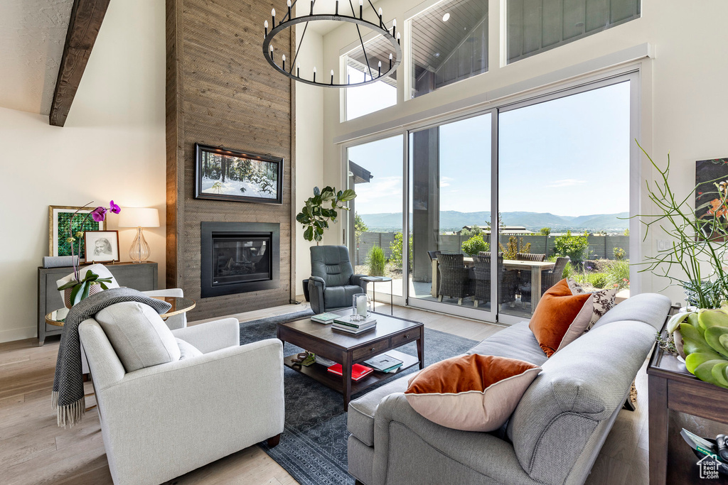 Living room with a mountain view, a high ceiling, hardwood / wood-style flooring, and a fireplace