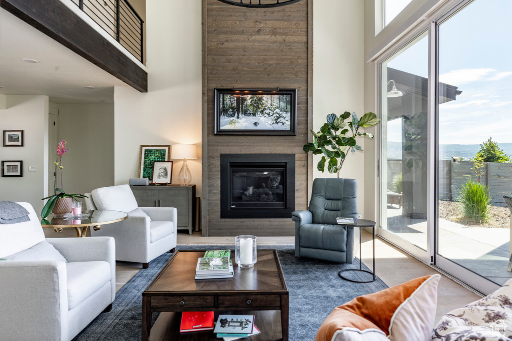 Living room featuring a towering ceiling, plenty of natural light, and a fireplace