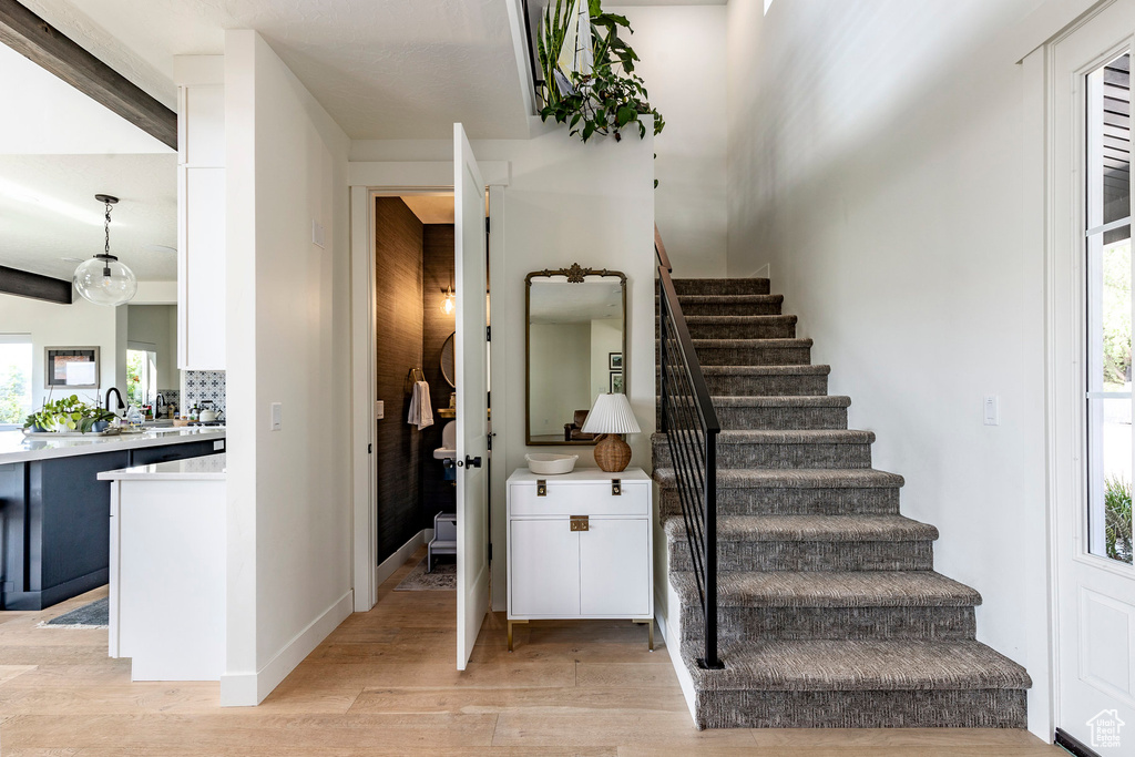 Stairs with a wealth of natural light and light wood-type flooring