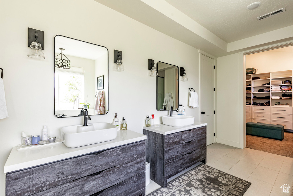 Bathroom with tile flooring, oversized vanity, and double sink