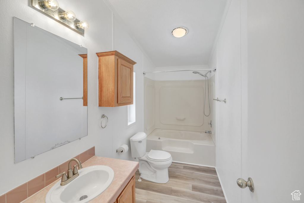 Full bathroom featuring wood-type flooring, toilet, shower / washtub combination, and vanity