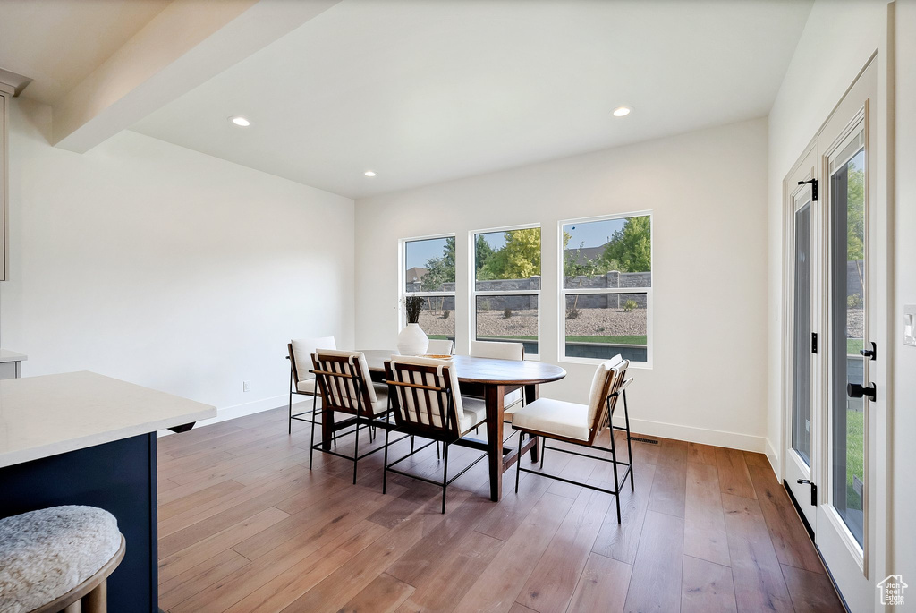 Dining space with beam ceiling and hardwood / wood-style floors