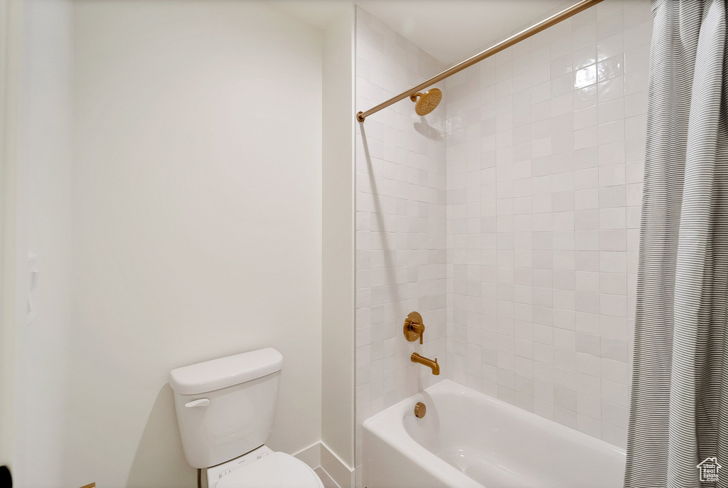 Bathroom featuring toilet and shower / bath combo