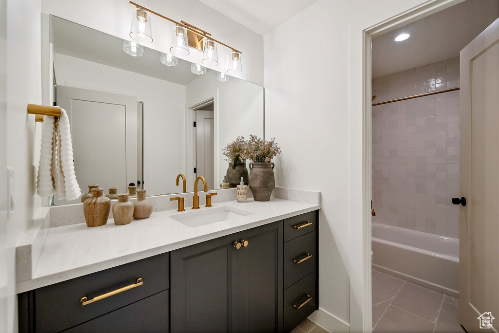 Bathroom featuring vanity, tiled shower / bath, and tile patterned floors