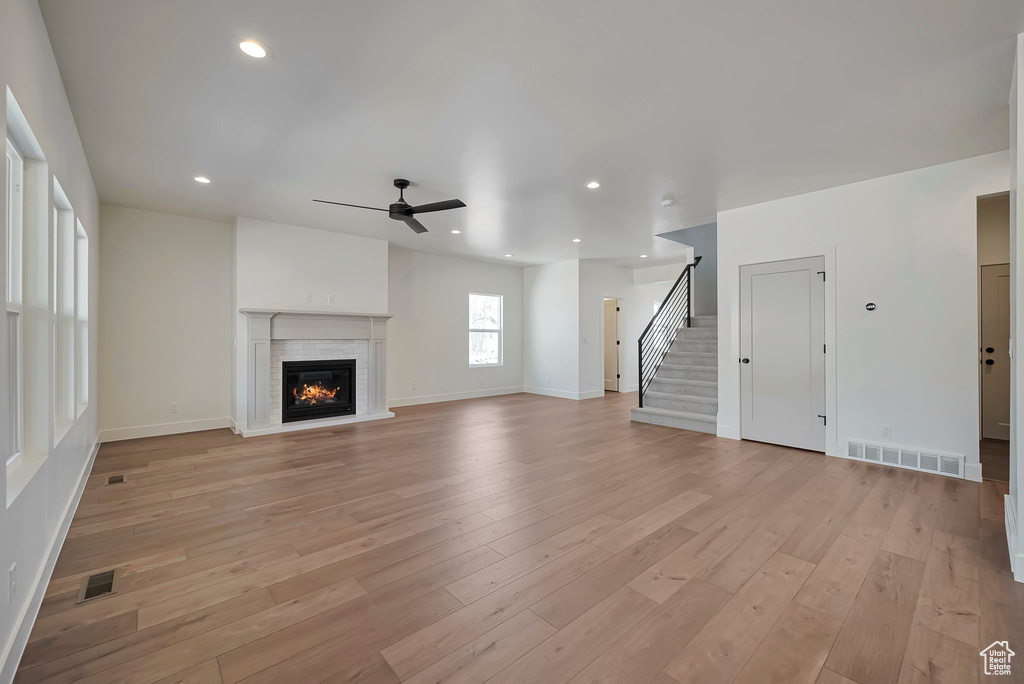 Unfurnished living room with ceiling fan and light hardwood / wood-style floors