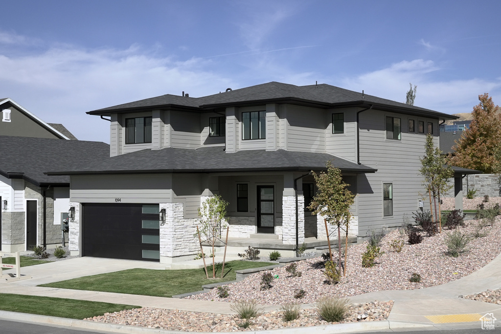 Prairie-style home featuring covered porch and a garage