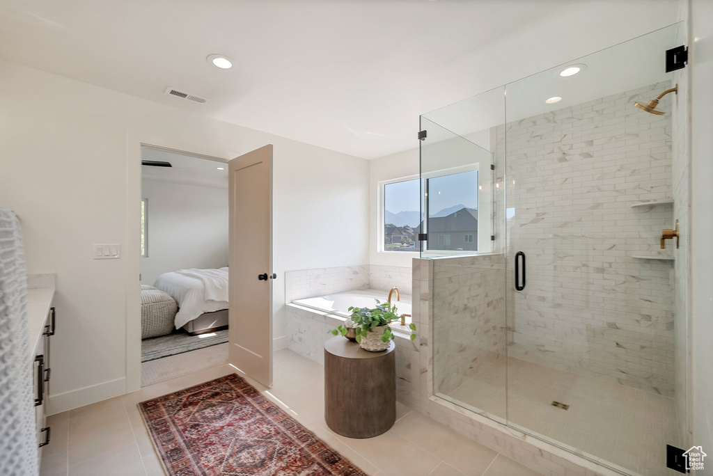 Bathroom featuring independent shower and bath, vanity, and tile patterned flooring