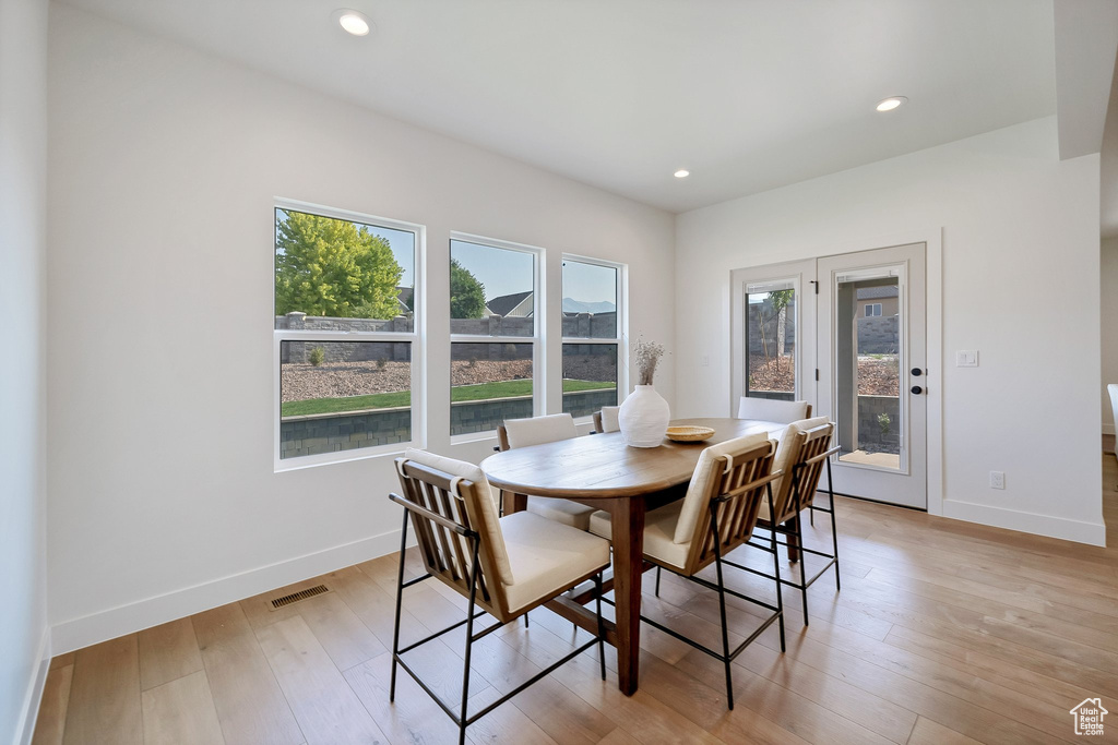 Dining room with a wealth of natural light and light wood-type flooring