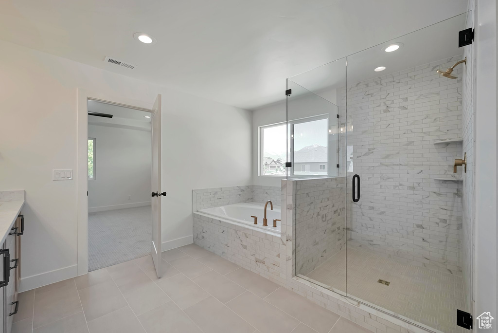 Bathroom featuring tile flooring, vanity, and plus walk in shower