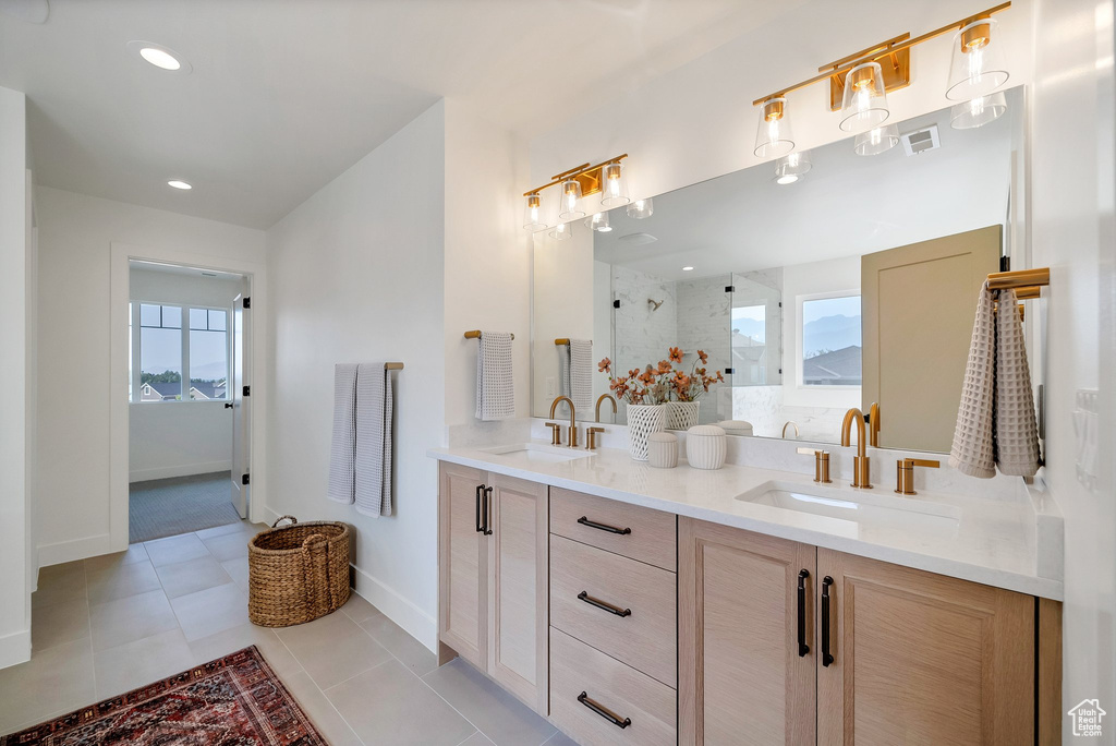 Bathroom with dual vanity, tile patterned floors, and plenty of natural light