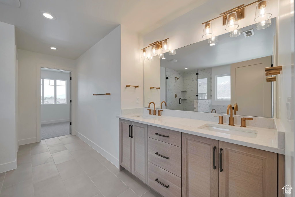 Bathroom with dual bowl vanity, tile flooring, and a tile shower