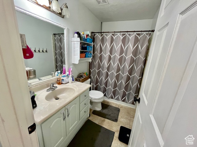 Bathroom with tile floors, toilet, and large vanity