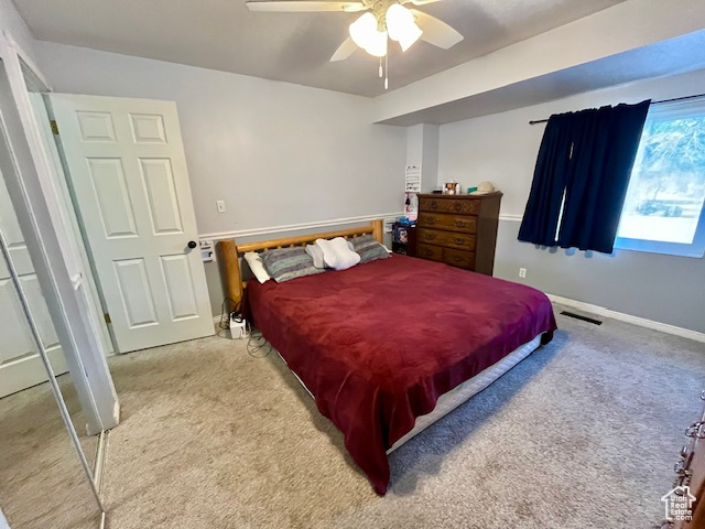 Carpeted bedroom with a closet and ceiling fan