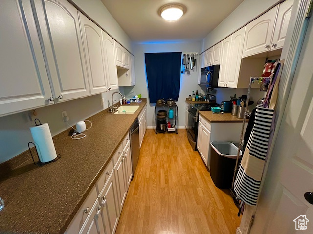 Kitchen featuring white cabinets, appliances with stainless steel finishes, sink, and light hardwood / wood-style floors