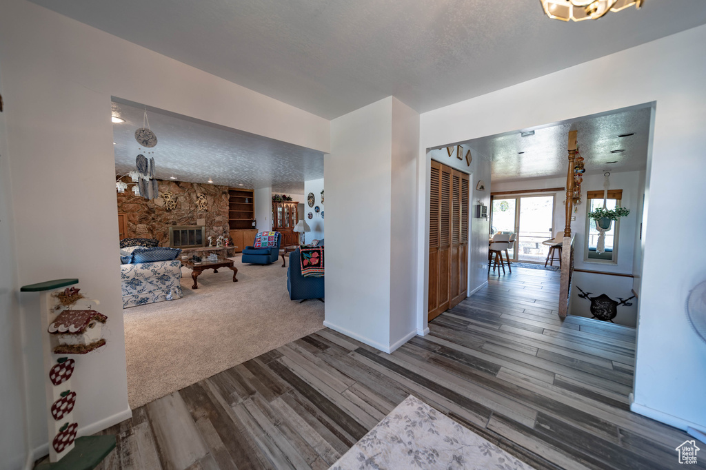 Hall with hardwood / wood-style flooring and a textured ceiling