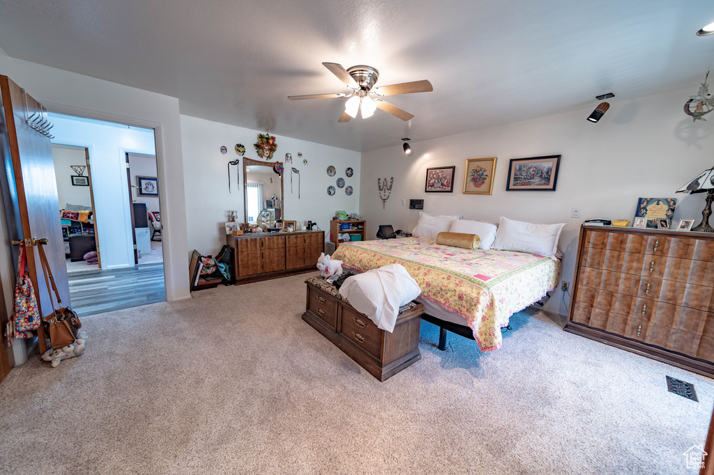 Carpeted bedroom featuring ceiling fan