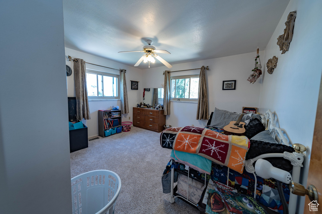 Carpeted bedroom featuring ceiling fan