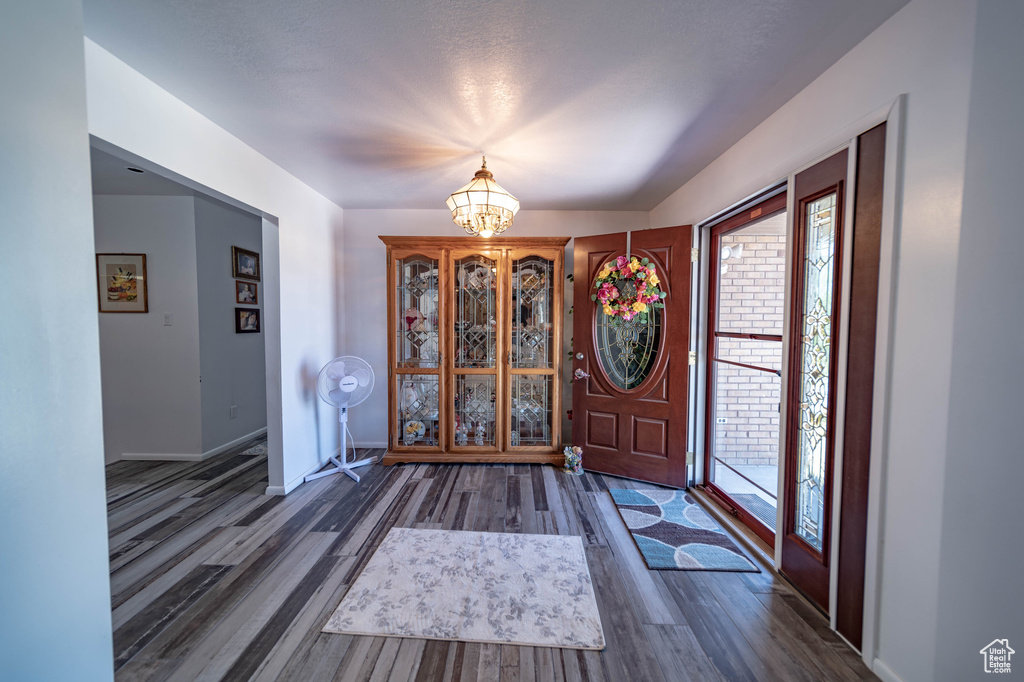 Entrance foyer featuring a notable chandelier and dark hardwood / wood-style floors