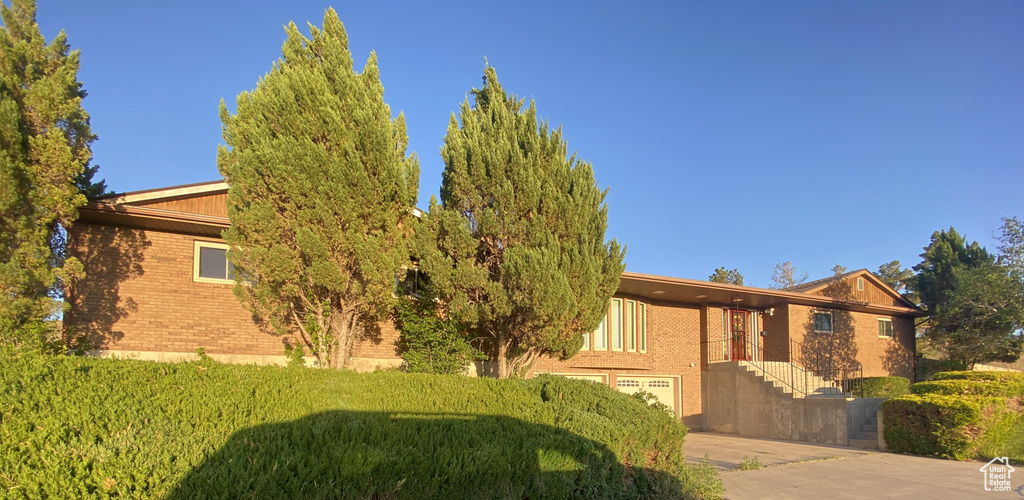 View of front of property featuring a garage and a front yard