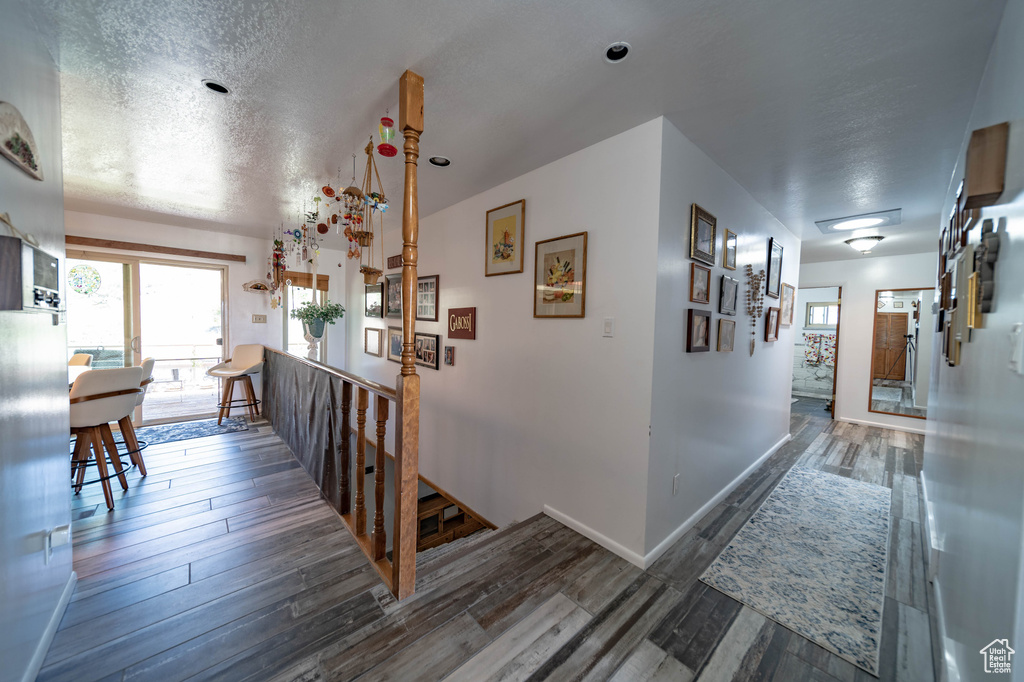 Corridor featuring dark hardwood / wood-style flooring and a textured ceiling