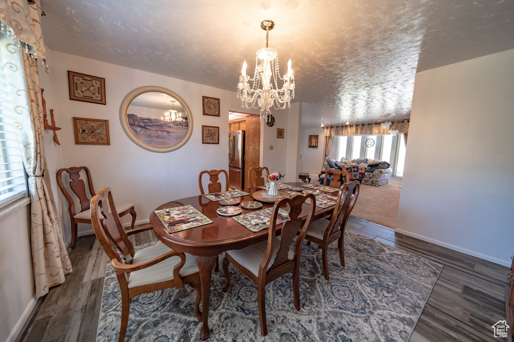 Dining area featuring a chandelier, a textured ceiling, plenty of natural light, and hardwood / wood-style flooring