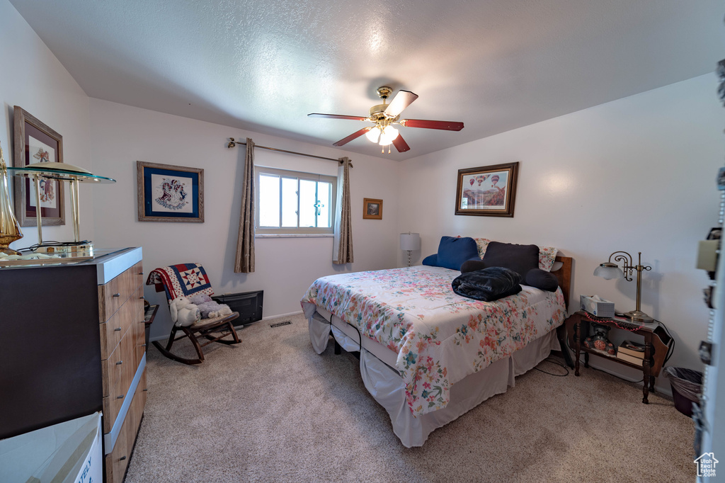 Carpeted bedroom with ceiling fan