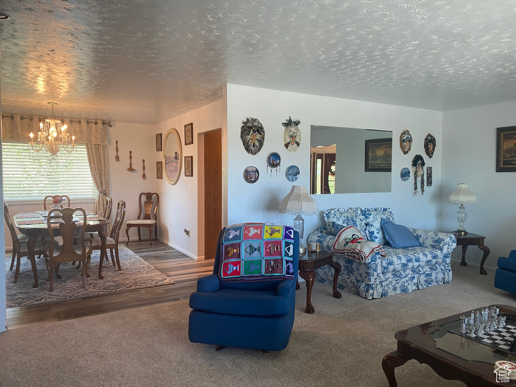 Carpeted living room with a textured ceiling and an inviting chandelier