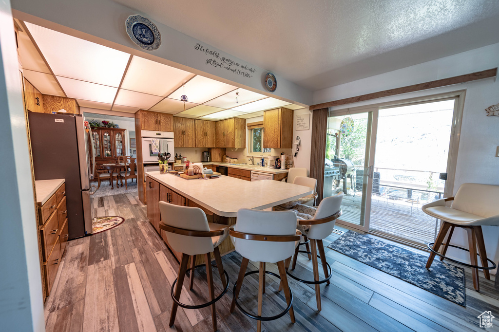 Kitchen with stainless steel refrigerator, fridge, dark wood-type flooring, sink, and a breakfast bar