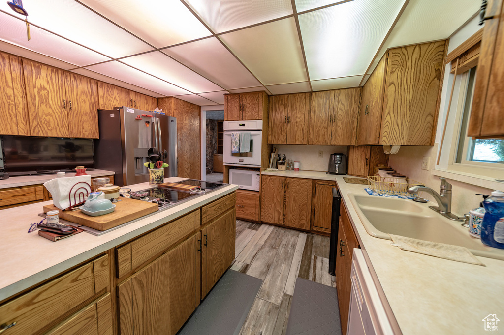 Kitchen featuring light hardwood / wood-style flooring, stainless steel fridge, dishwasher, sink, and double oven