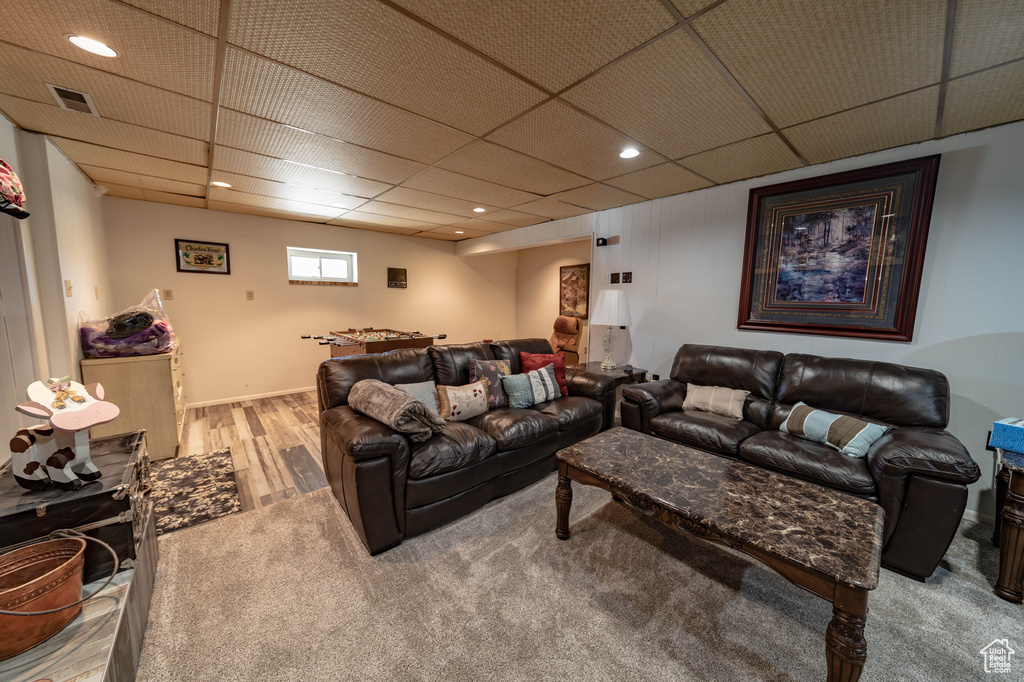 Carpeted living room featuring a drop ceiling