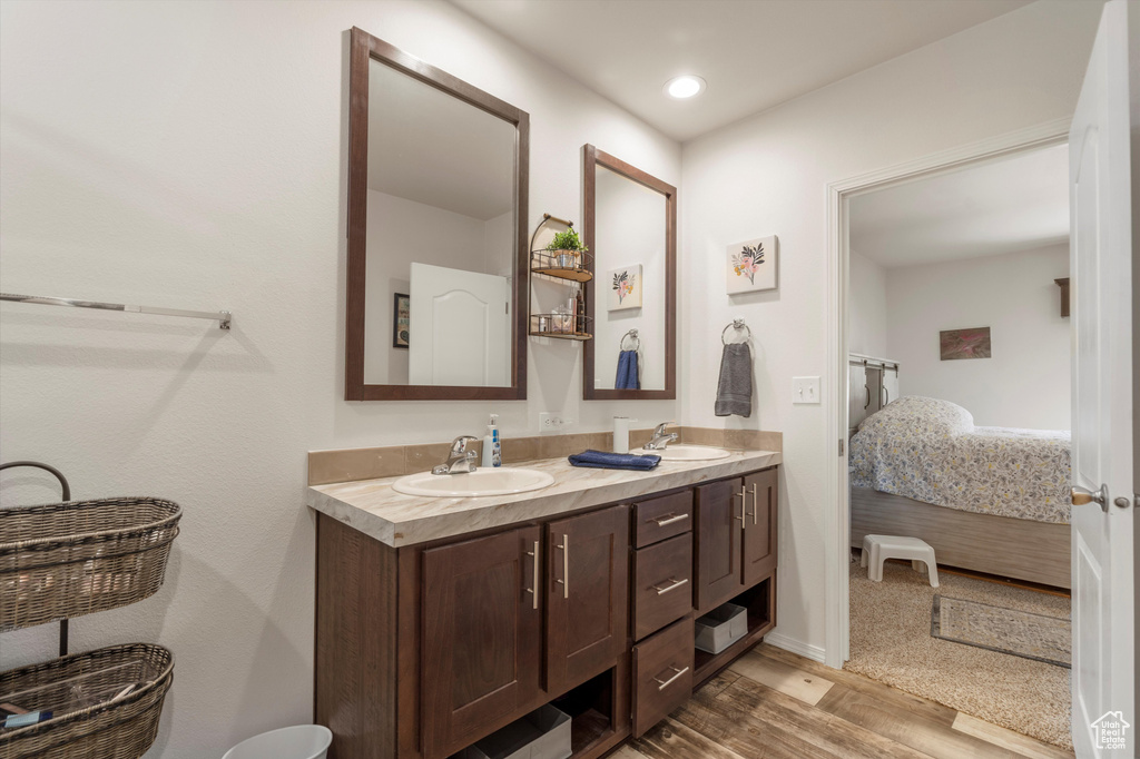 Bathroom with hardwood / wood-style floors, dual sinks, and large vanity