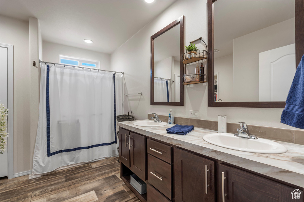 Bathroom featuring dual bowl vanity and hardwood / wood-style flooring