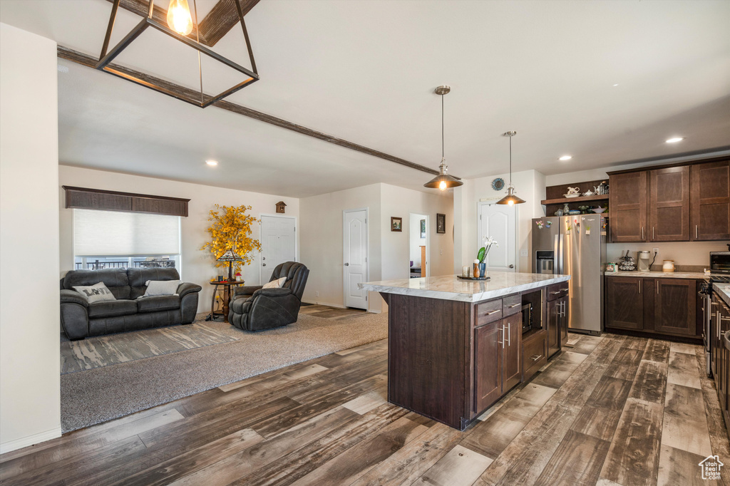 Kitchen with stainless steel appliances, dark brown cabinetry, a center island, and dark hardwood / wood-style floors