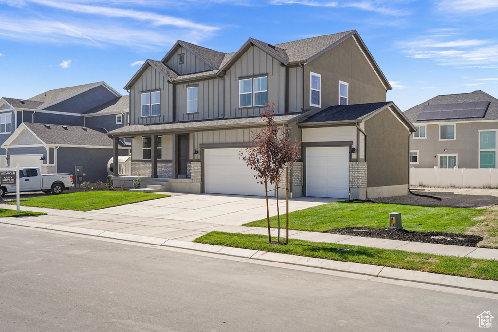 View of front facade with a front yard and a garage