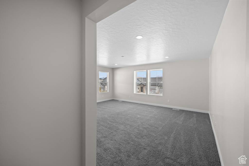 Empty room with carpet floors and a textured ceiling