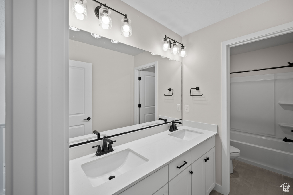 Full bathroom featuring bathtub / shower combination, tile patterned floors, vanity, and toilet