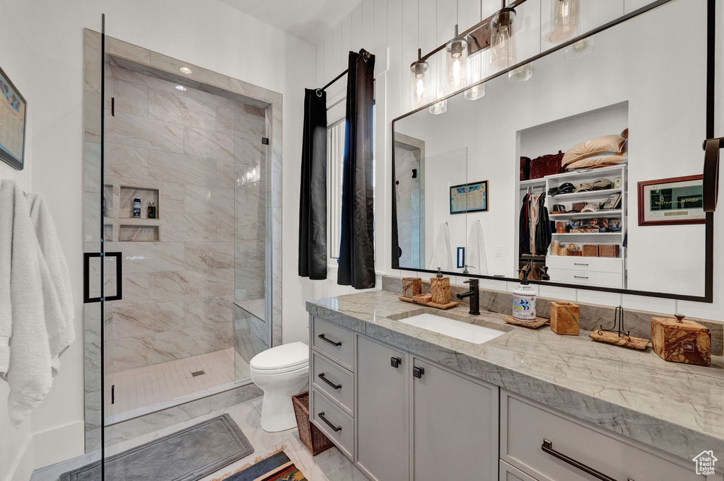 Bathroom with tile floors, walk in shower, toilet, and vanity