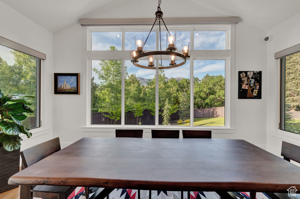 Dining space featuring a notable chandelier and vaulted ceiling