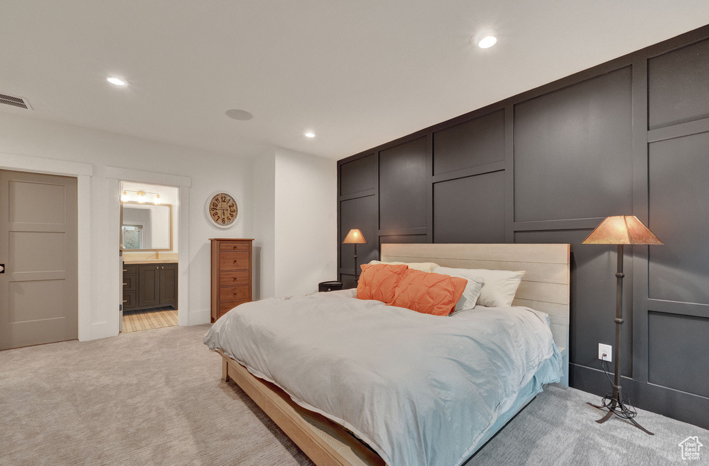 Bedroom with light carpet and ensuite bath