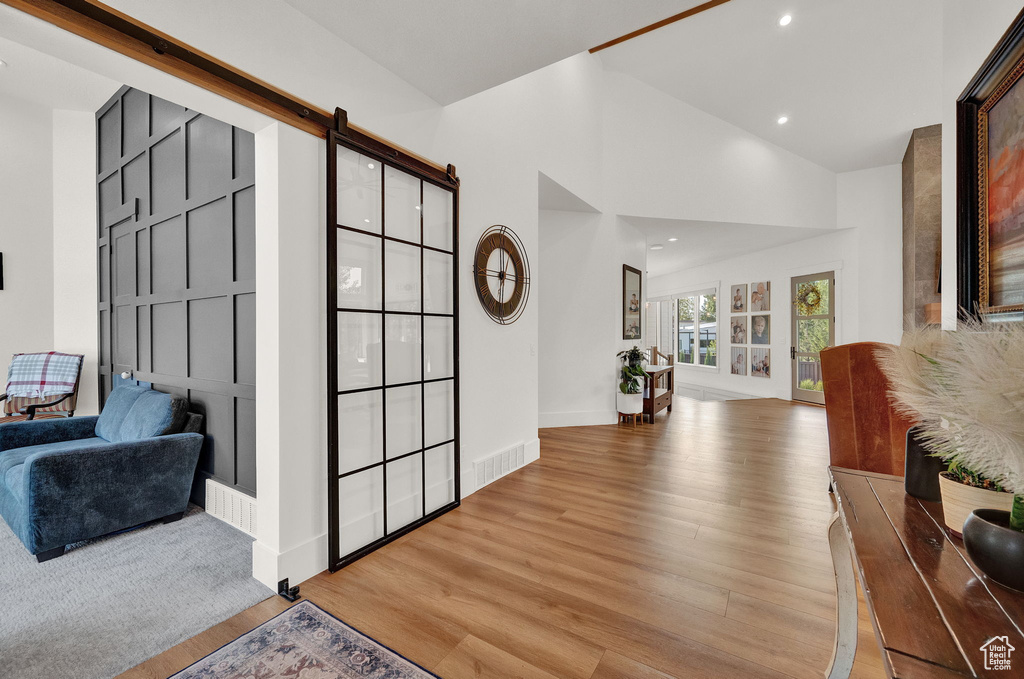 Foyer with a barn door and light colored carpet