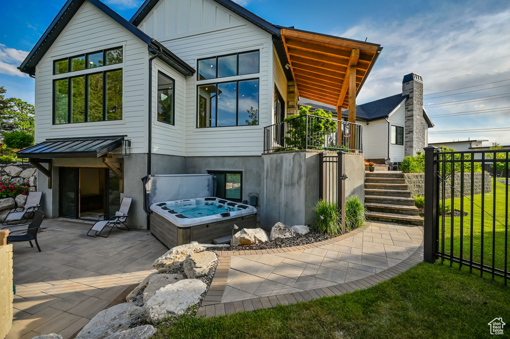 Rear view of house featuring a patio area and a hot tub