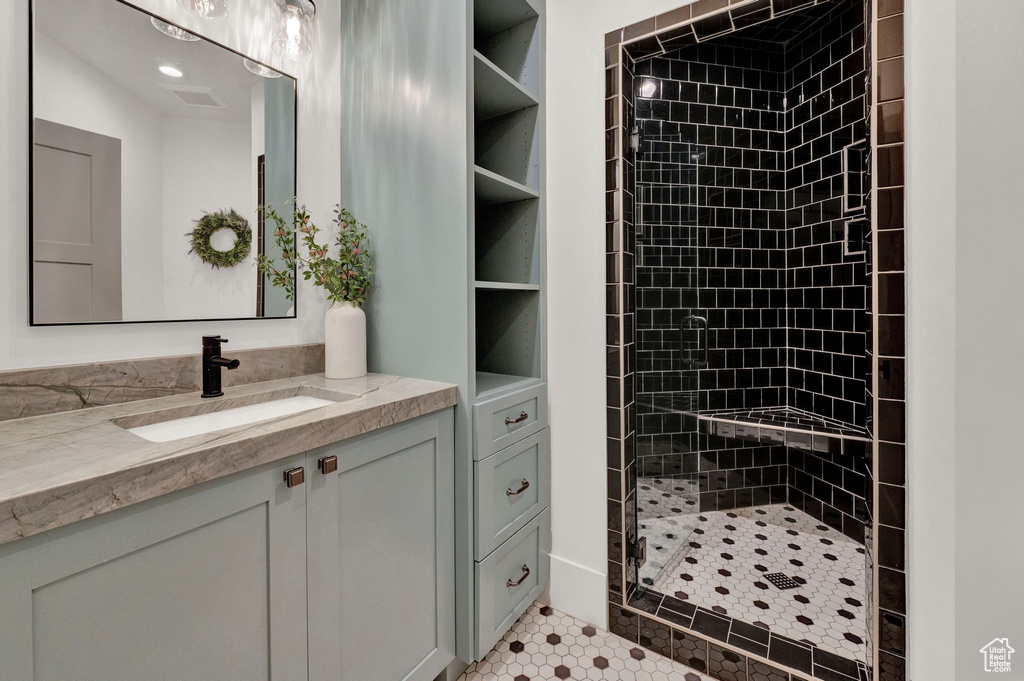 Bathroom with a tile shower, tile floors, and vanity