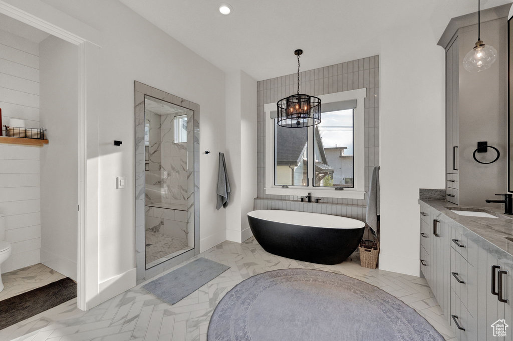 Bathroom featuring tile flooring, walk in shower, vanity, and toilet