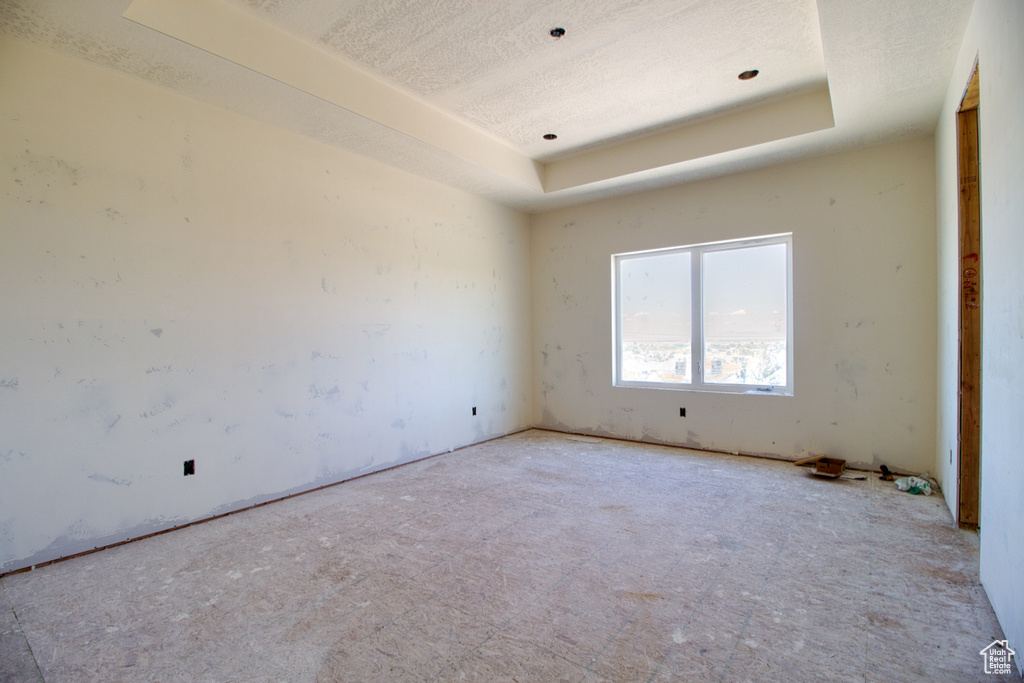 Spare room featuring a textured ceiling and a tray ceiling