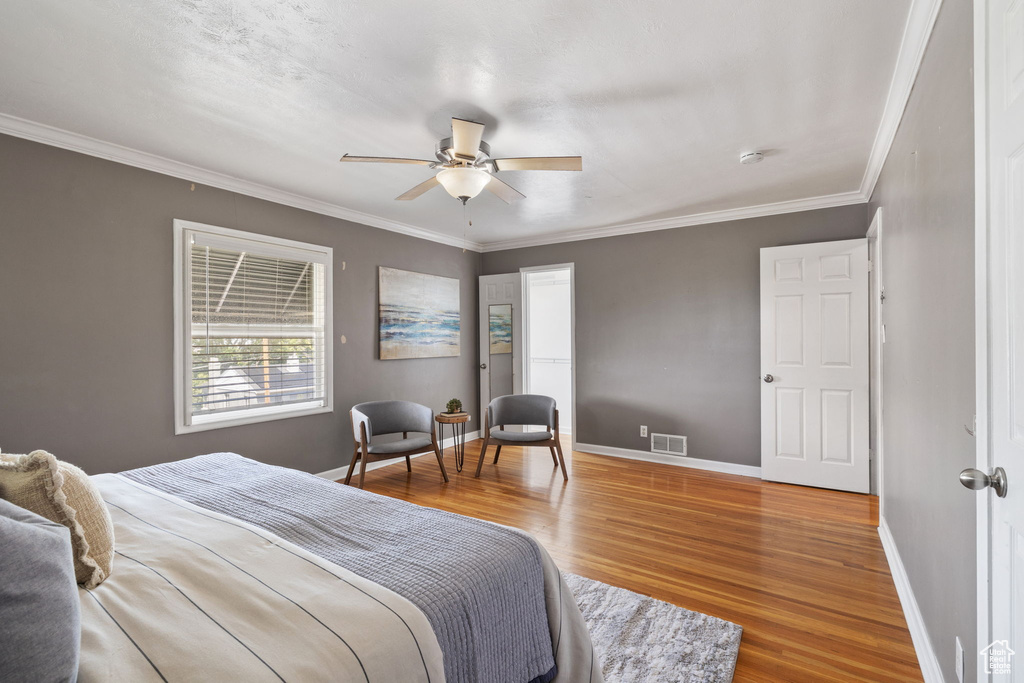 Bedroom featuring ceiling fan, ornamental molding, and hardwood / wood-style flooring