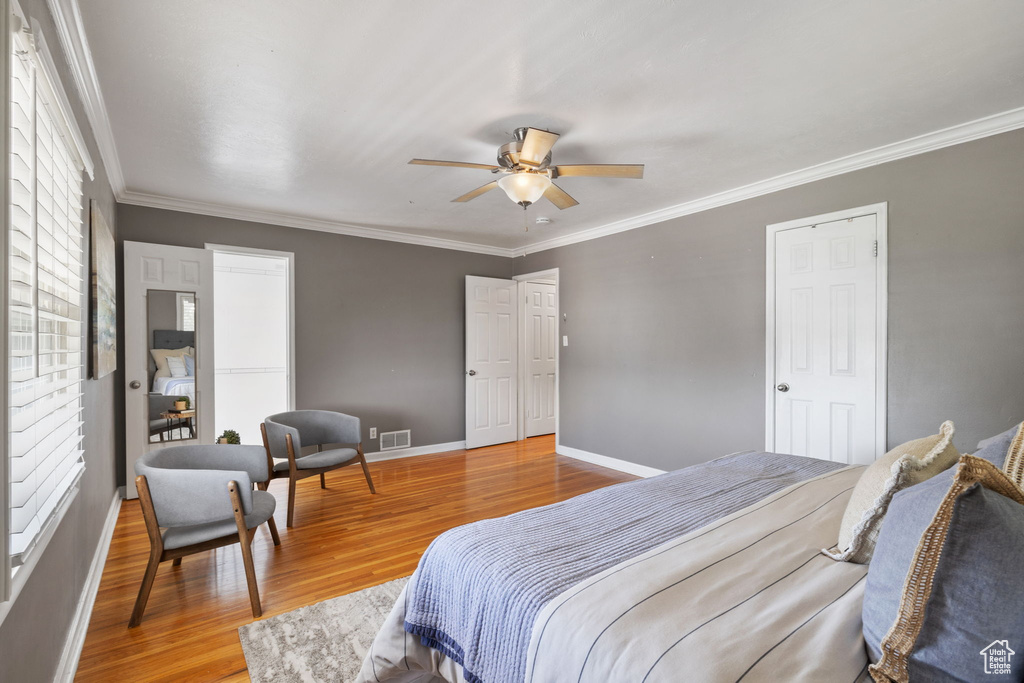 Bedroom featuring ceiling fan, light hardwood / wood-style floors, and crown molding